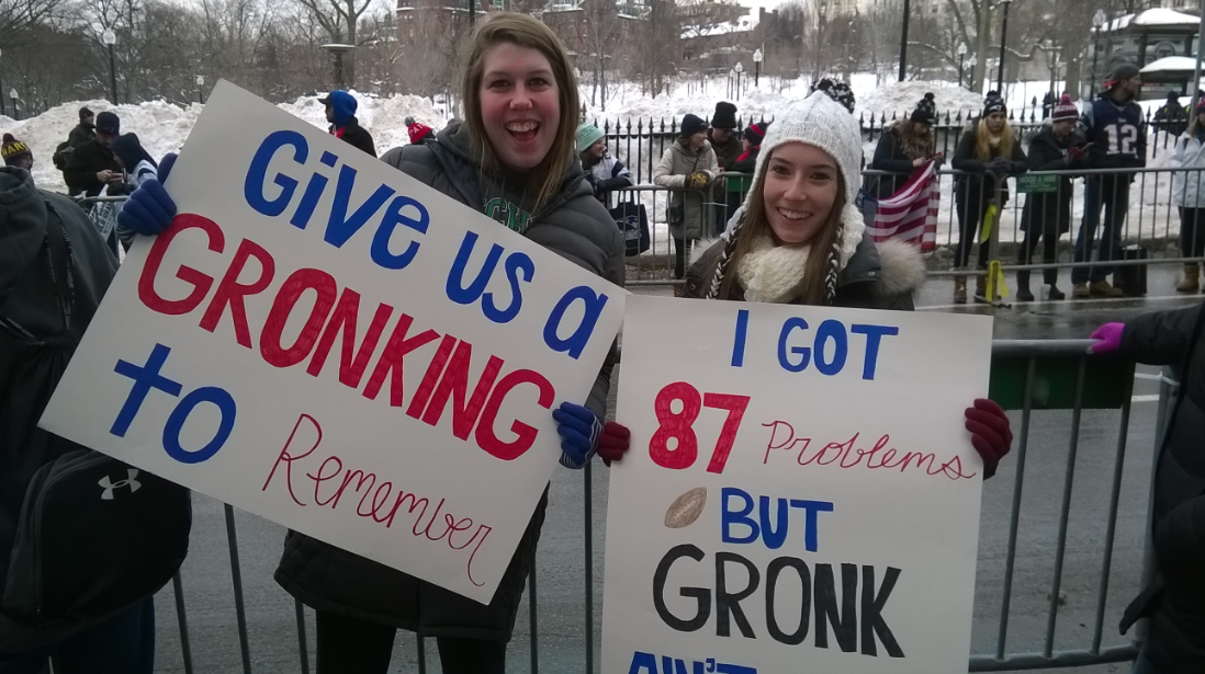 Patriots fans hold signs based on All-Pro tight end Rob Gronkowski. The sign on the right reads, "I got 87 problems but Gronk ain't 1."